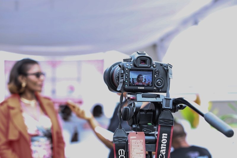 Woman standing out of focus in front of a camera outside